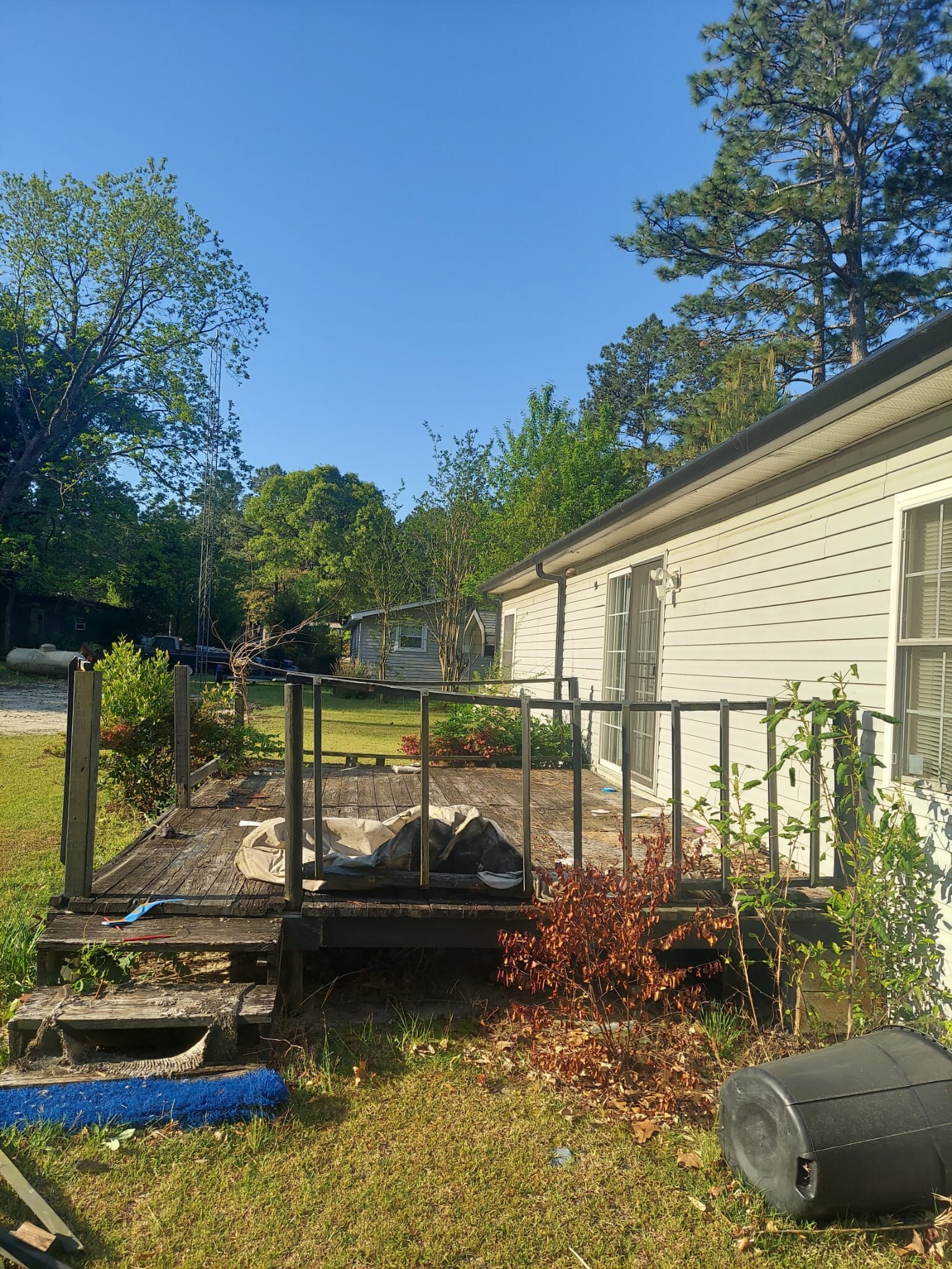 Old worn wooden deck with weathered boards and railings before rebuild